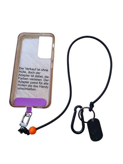 Original Phoneleash Schwarz Orange Handykette mit elastischem Band für sicheren, stilvollen Smartphone-Gebrauch. Detail Adapterbefestigung in der Handyhülle. In Deutschland gefertigt, bietet sie Langlebigkeit und ein dezentes Design mit einer Friedensbotschaft durch ein handgestanztes Peace-Zeichen und Herz.